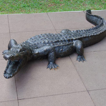tan interlocking playground tiles installed on playground with alligator statue