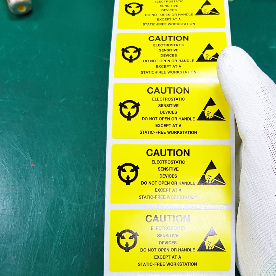 holding electrostatic caution sticker at static free workstation