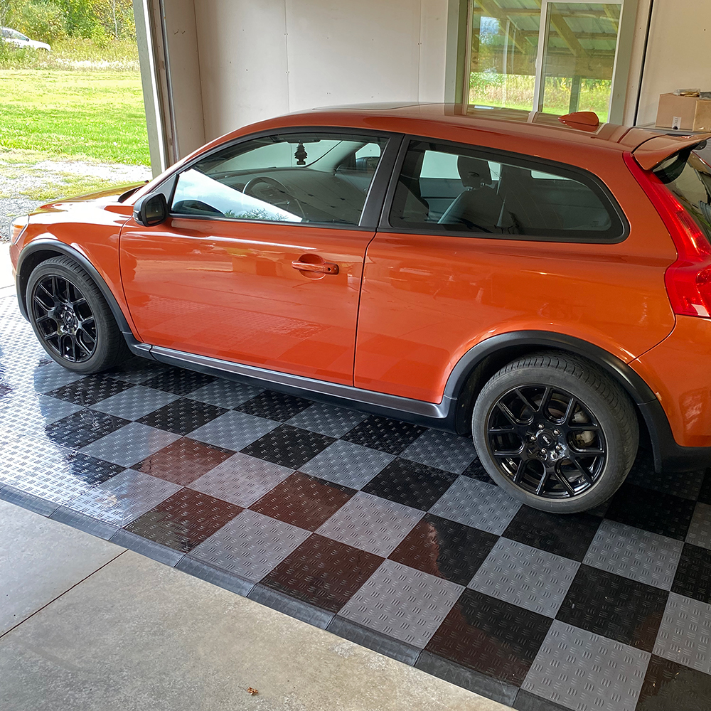 car in garage sitting on garage tiles with border ramp edges