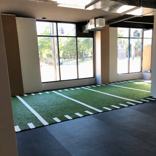 Indoor V-Max Artificial Gym Turf with yardlines and hashmarks installed in gym with rubber flooring