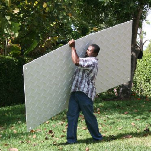 person carrying clear ground protection mat