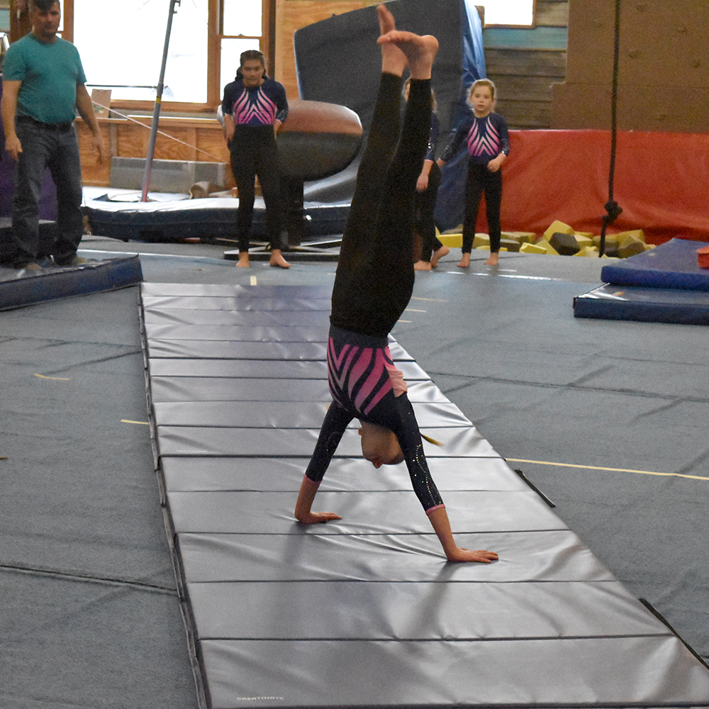 girl doing gymnastics on 4x10 foot blue folding panel mats in gymnastics studio