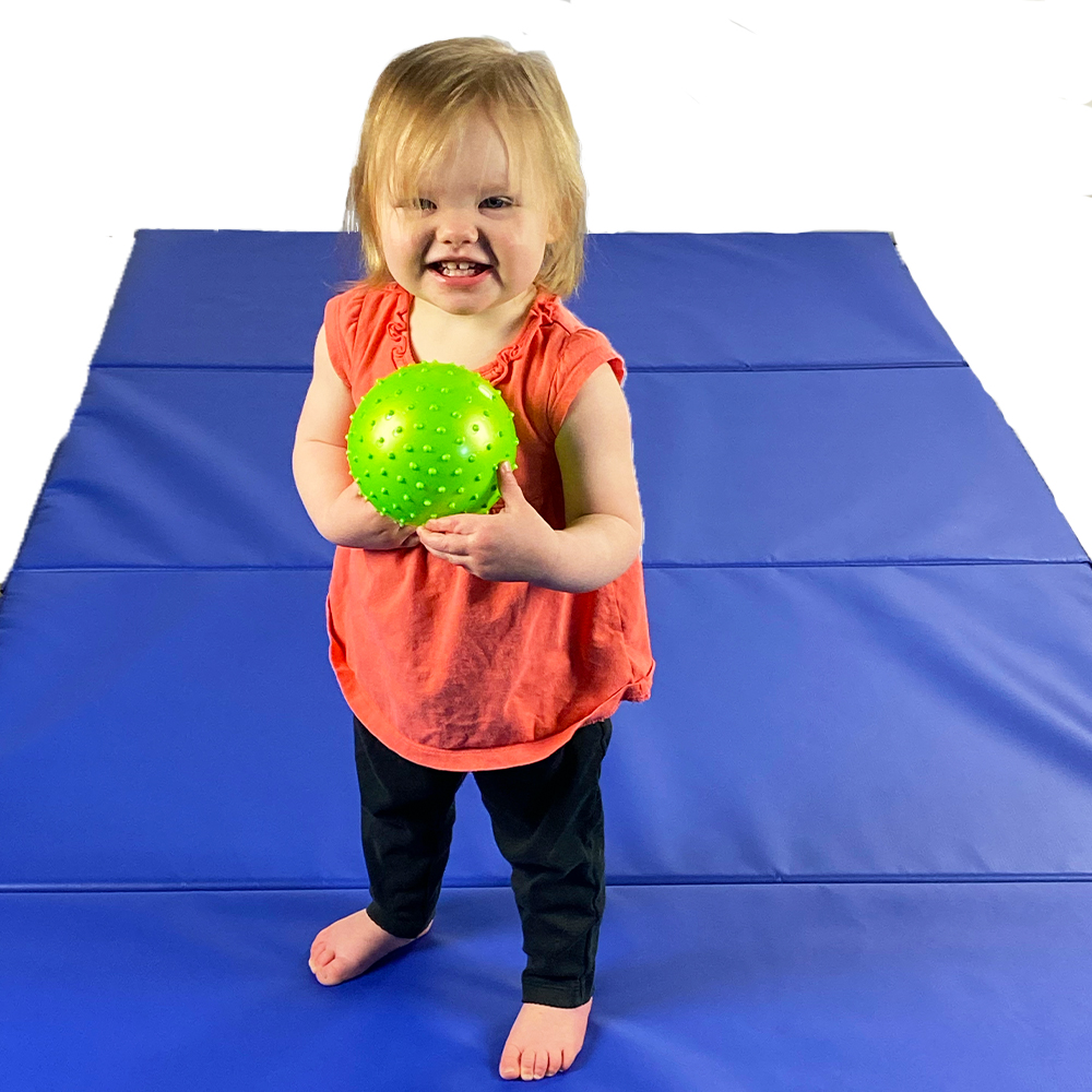 toddler plays on folding gym mats for home play or daycare