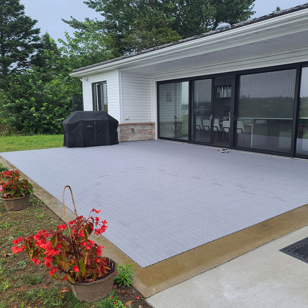 gray outdoor patio tiles installed on a back concrete patio