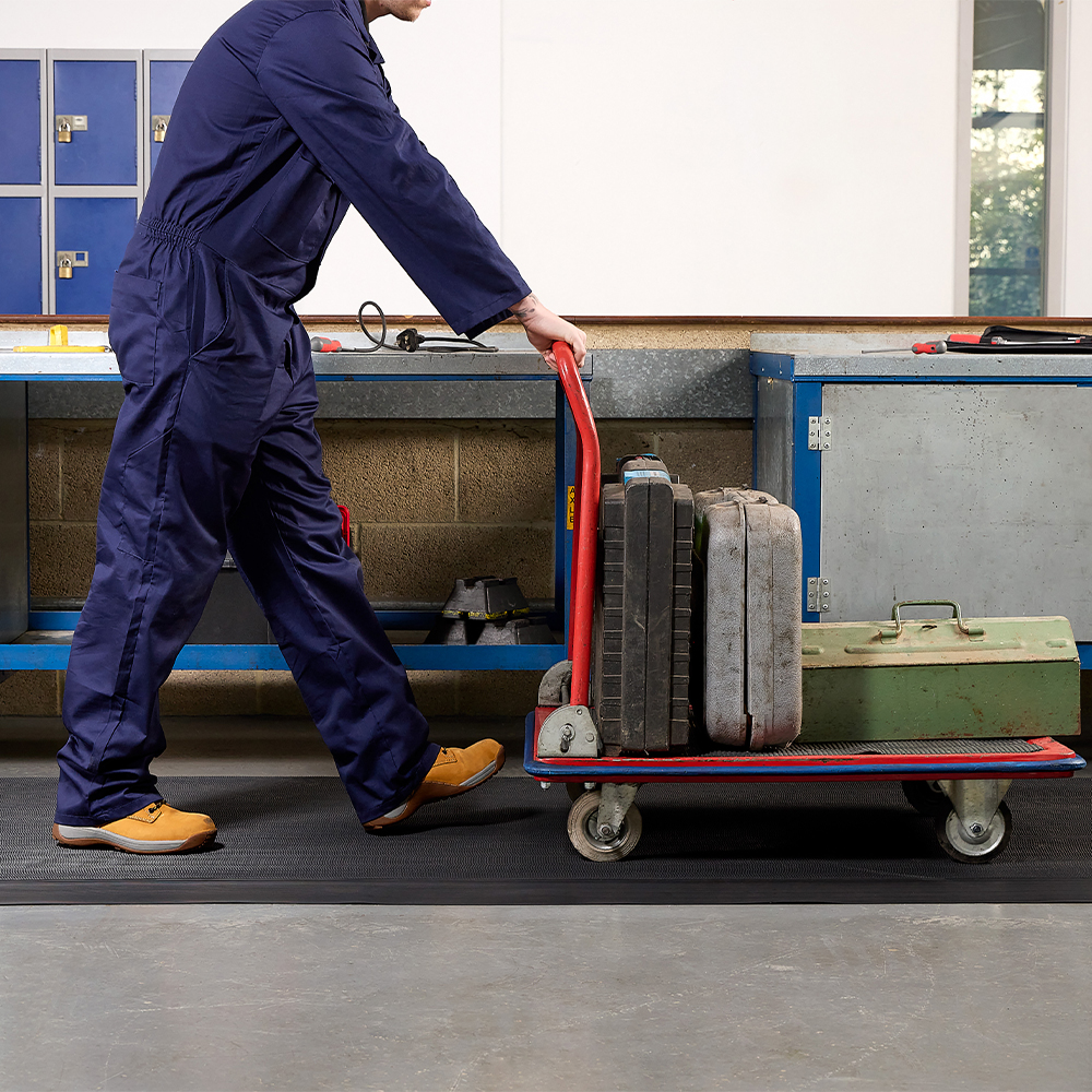 person with cart walking on Firmagrip Industrial Matting in industrial facility