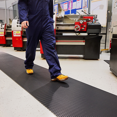person walking on heronair matting in manufacturing facilitiy