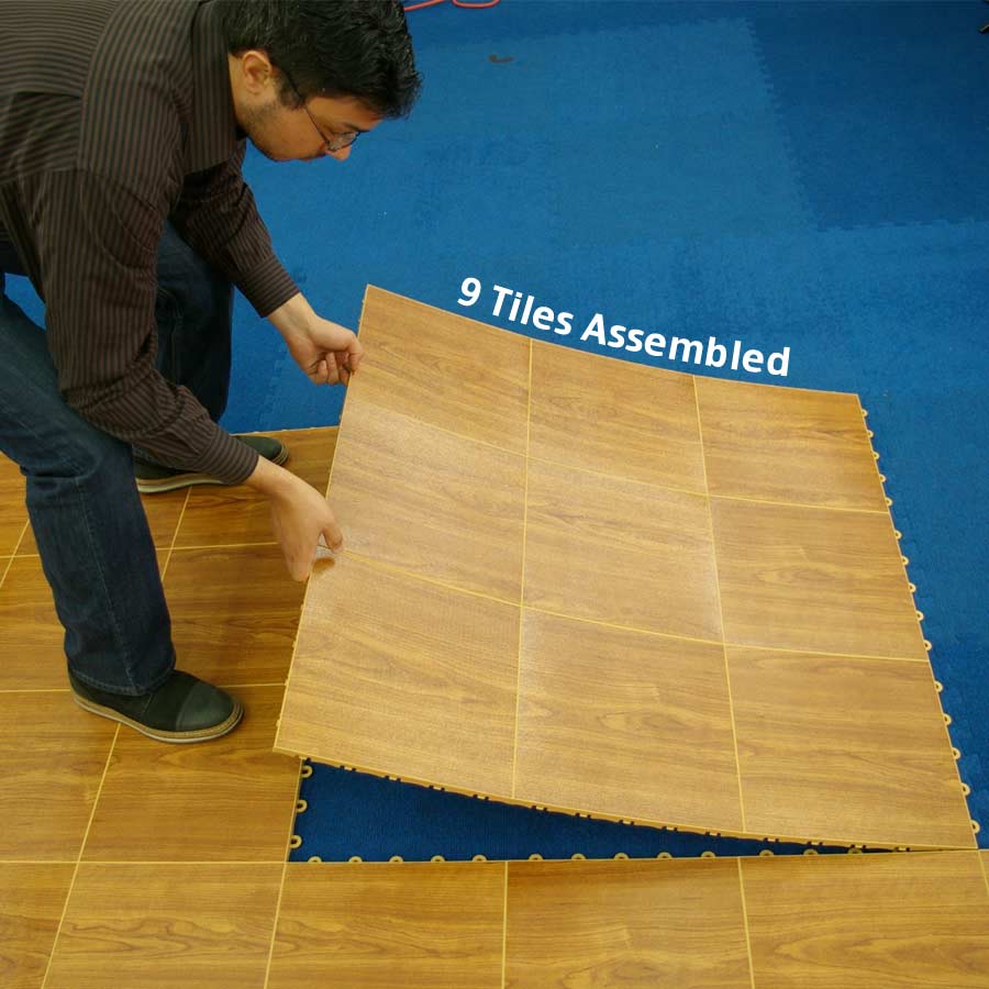 person installing portable dance floor tiles over carpet
