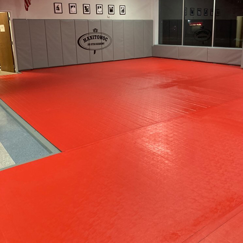 Gray Jiu Jitsu Safety Wall Pads with red roll out mats in martial arts studio