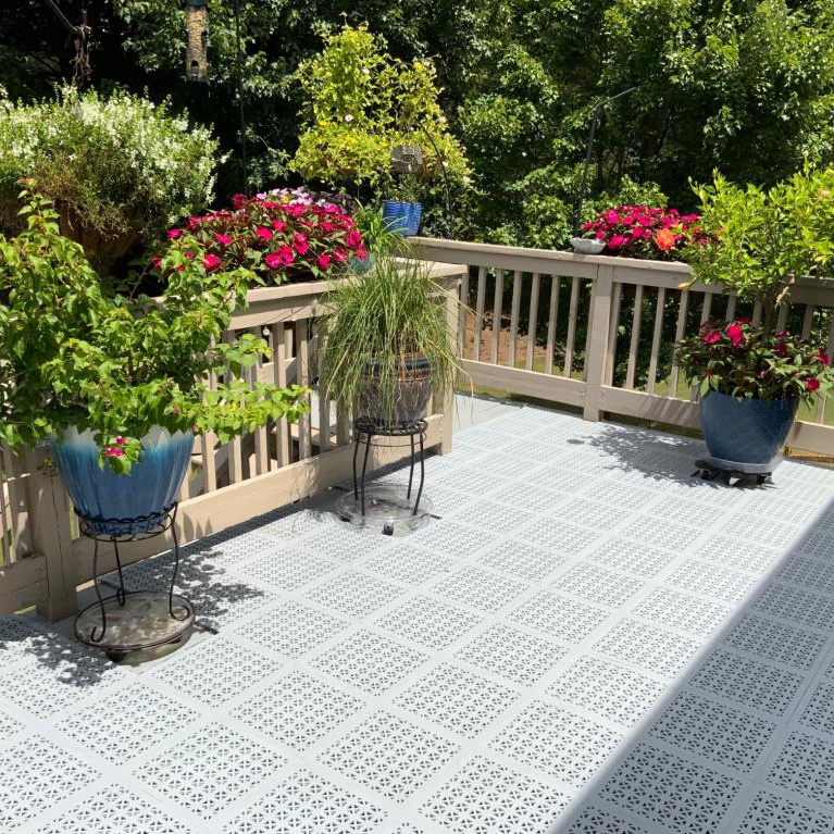 gray StayLock Perforated Decking Tiles used over top of existing deck with flowers