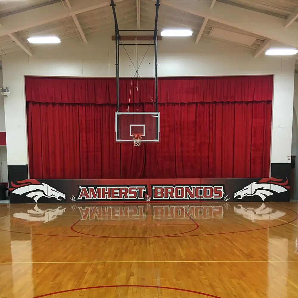 custom stage pads padding with school graphics in gymnasium
