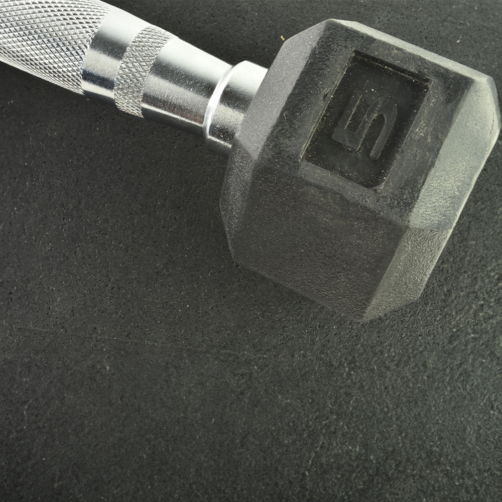 close up of dumbbell on black geneva rubber flooring