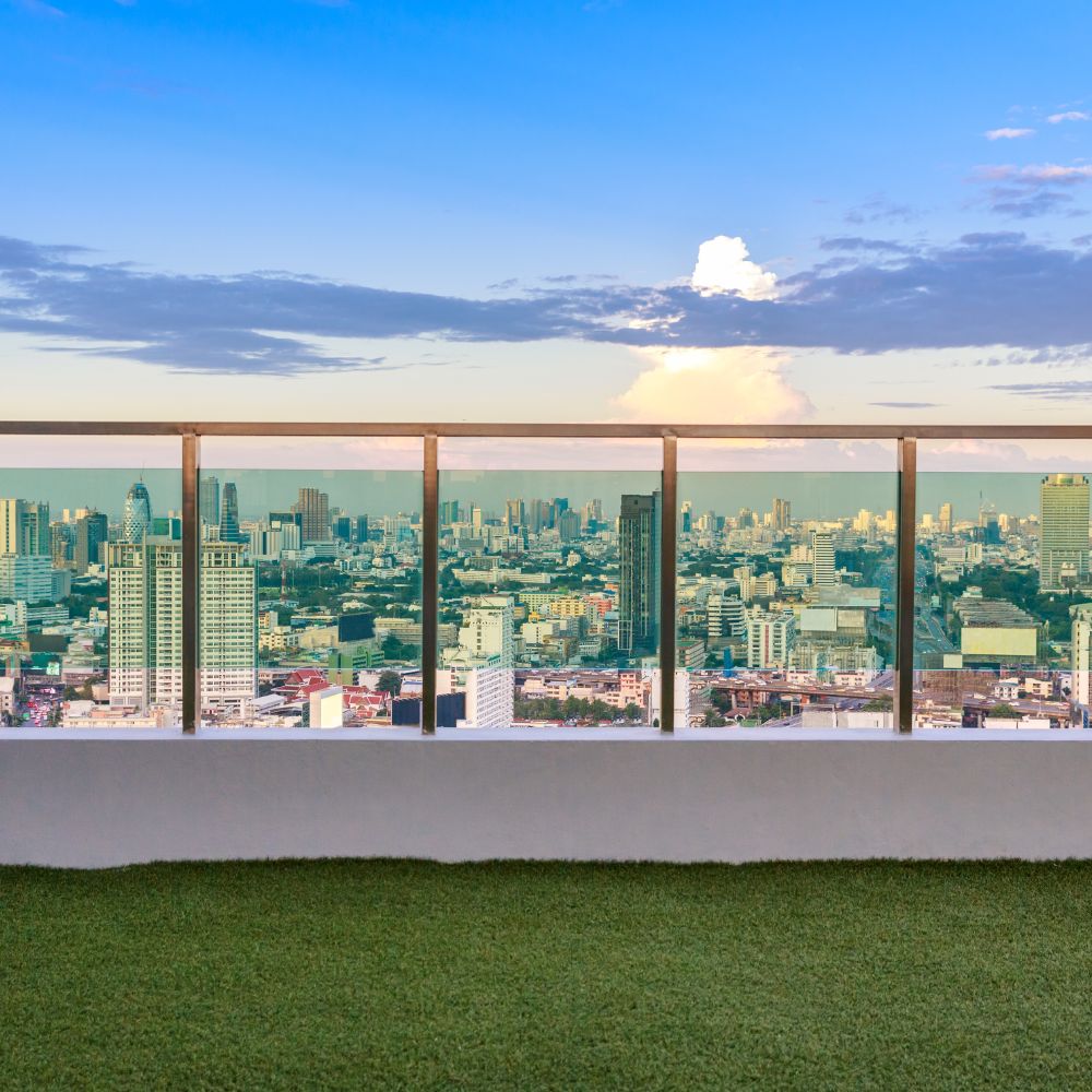 balcony with artificial grass flooring and concrete railing