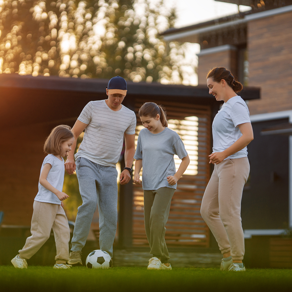 family playing on artificial turf outside at their home