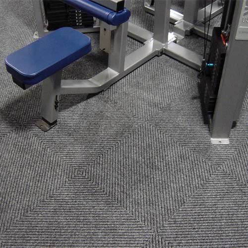 gray gym carpet tiles installed under weightlifting equipment
