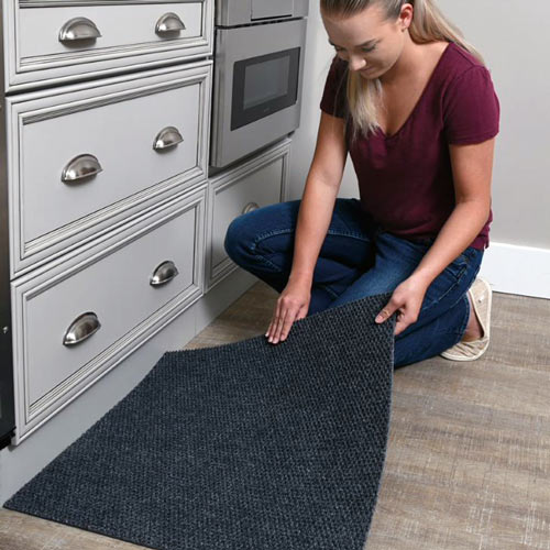 woman installing peel and stick carpet tiles