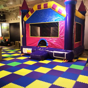 colorful foam mats in toddler play area with bouncy house