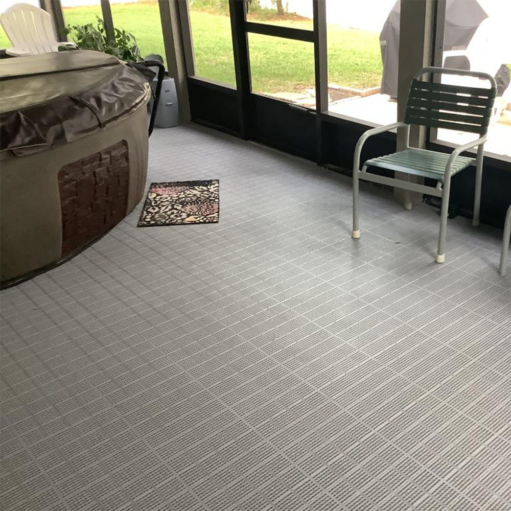 gray patio outdoor tiles installed in screen room featuring hot tub