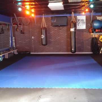 Boxing workout area in garage with foam floor mats