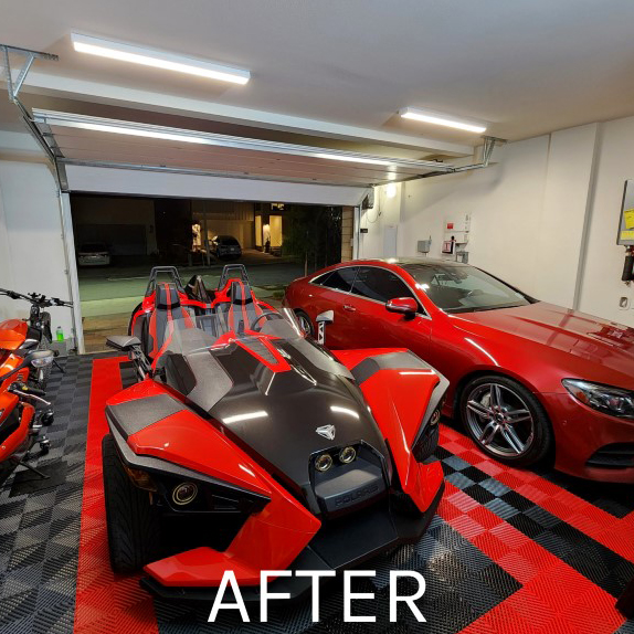 garage with cars showing red and gray raised interlocking tiles for flooring