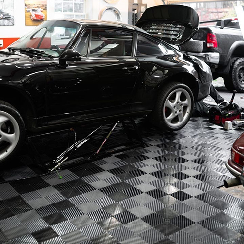 porsche Car Jacked up in garage shop with cool garage floor tiles 