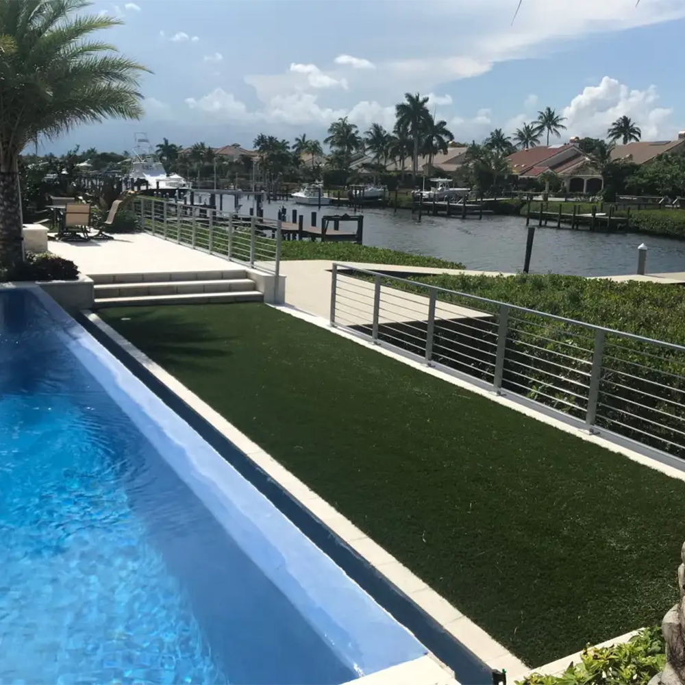 Endless Summer artificial turf next to outdoor pool along waterway with docks in residential ara