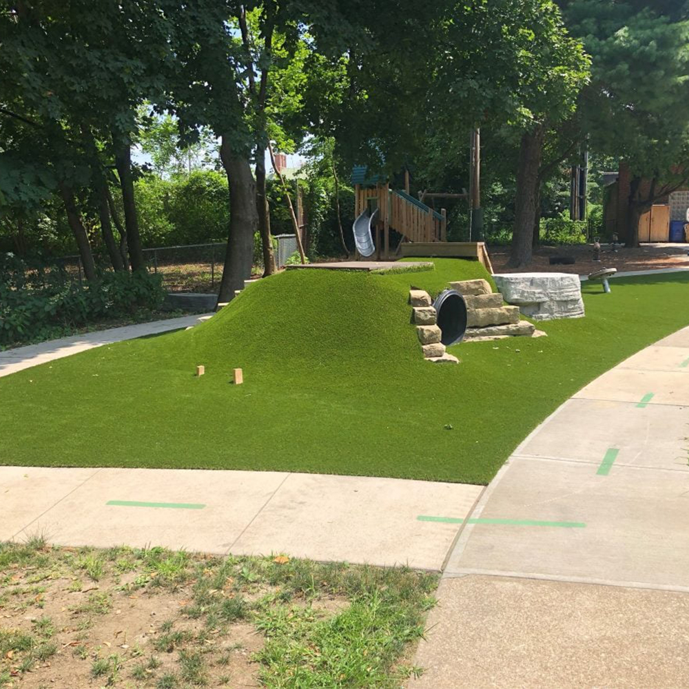 playground artificial turf surrounded by trees providing shade