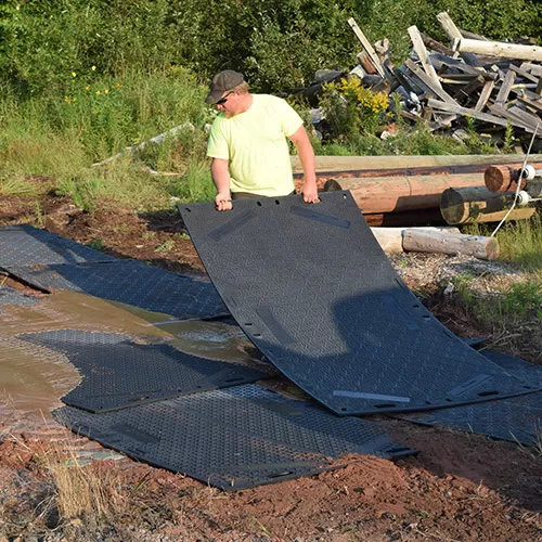 Laying ground protection mats in mud