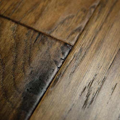 close up hand scraped wood plank flooring