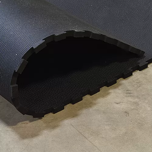 thick rubber horse stall mat folded over on floor