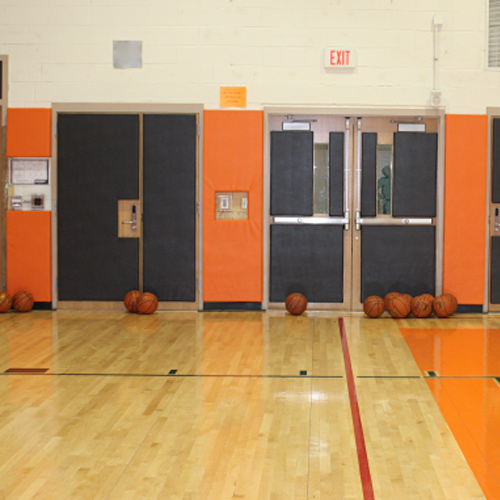 wood backed hanging wall pads in school gym
