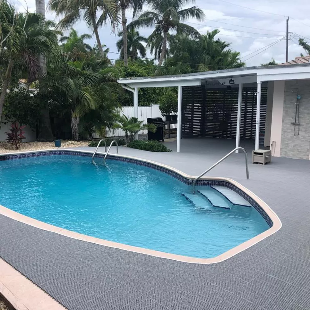 grey pvc tiles installed at house around outdoor in-ground pool