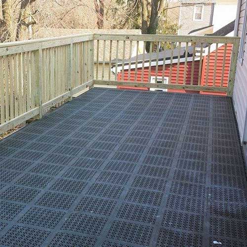 Rubberlike plastic perforated tile with drainage installed on wood deck