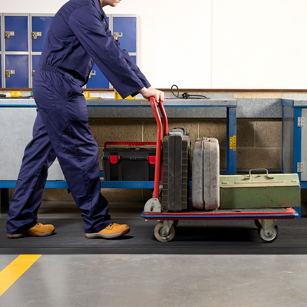 person with cart walking on Firmagrip Industrial Matting in industrial facility