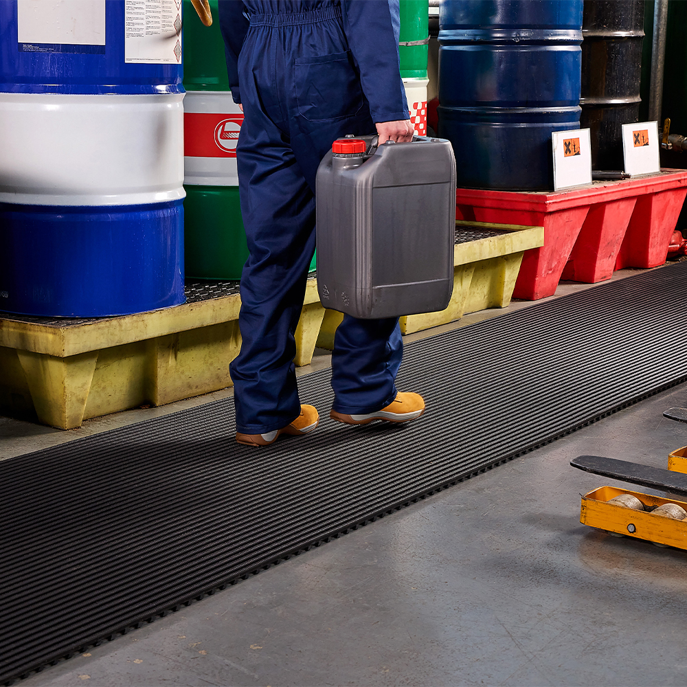 person walking on Flexigrid Industrial Matting in manufacturing facility