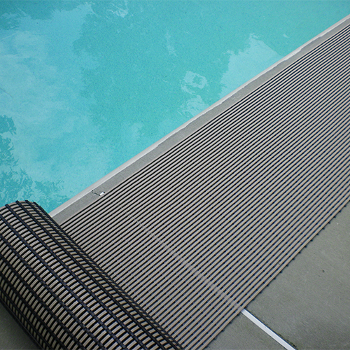 rolling out gray heronrib matting along poolside