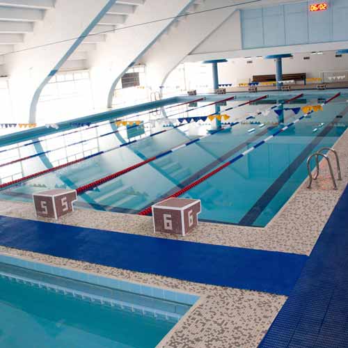 aquatic matting in blue color installed over ceramic tiles on indoor pool deck at aquatic center