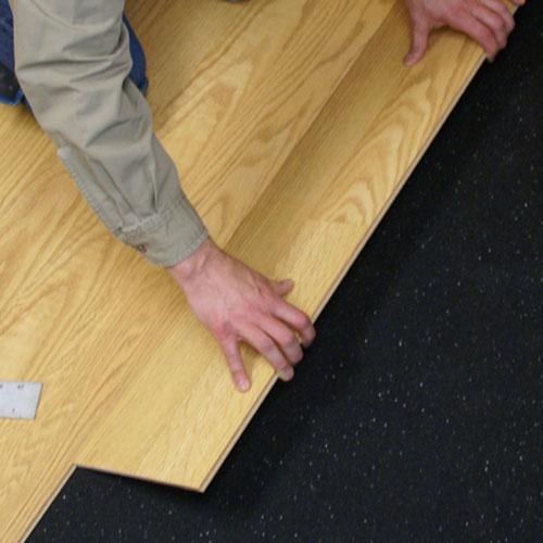 person installing laminate over rubber underlayment