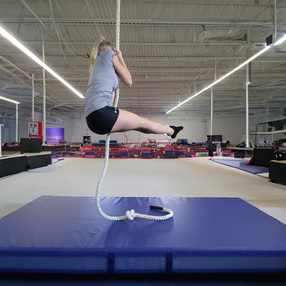 Girl hanging over Safety Landing Mat Non-Folding 4 Inch x 5x10 Ft. Royal Blue Mat under Side Hang Rope