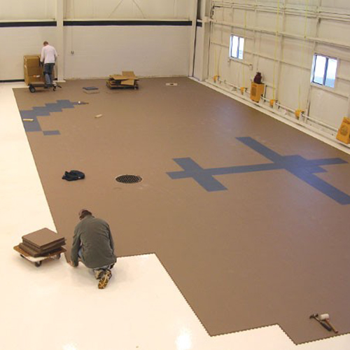 people installing tuff-seal floor tiles in aircraft hangar