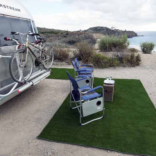 turf camping patio mats behind rv on lakefront