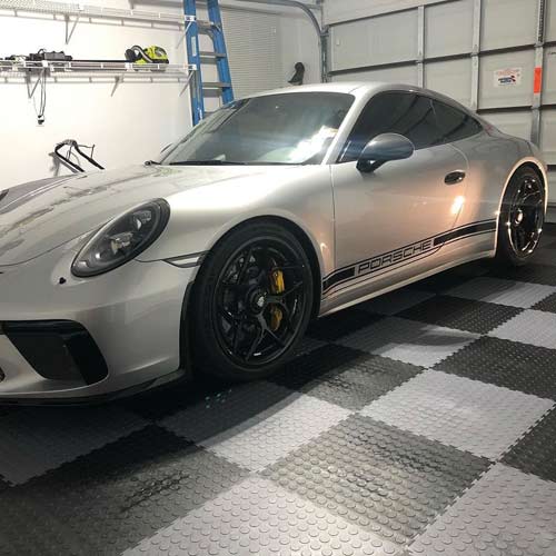 Coin Top PVC tiles in black and gray checkerboard pattern in garage with porsche