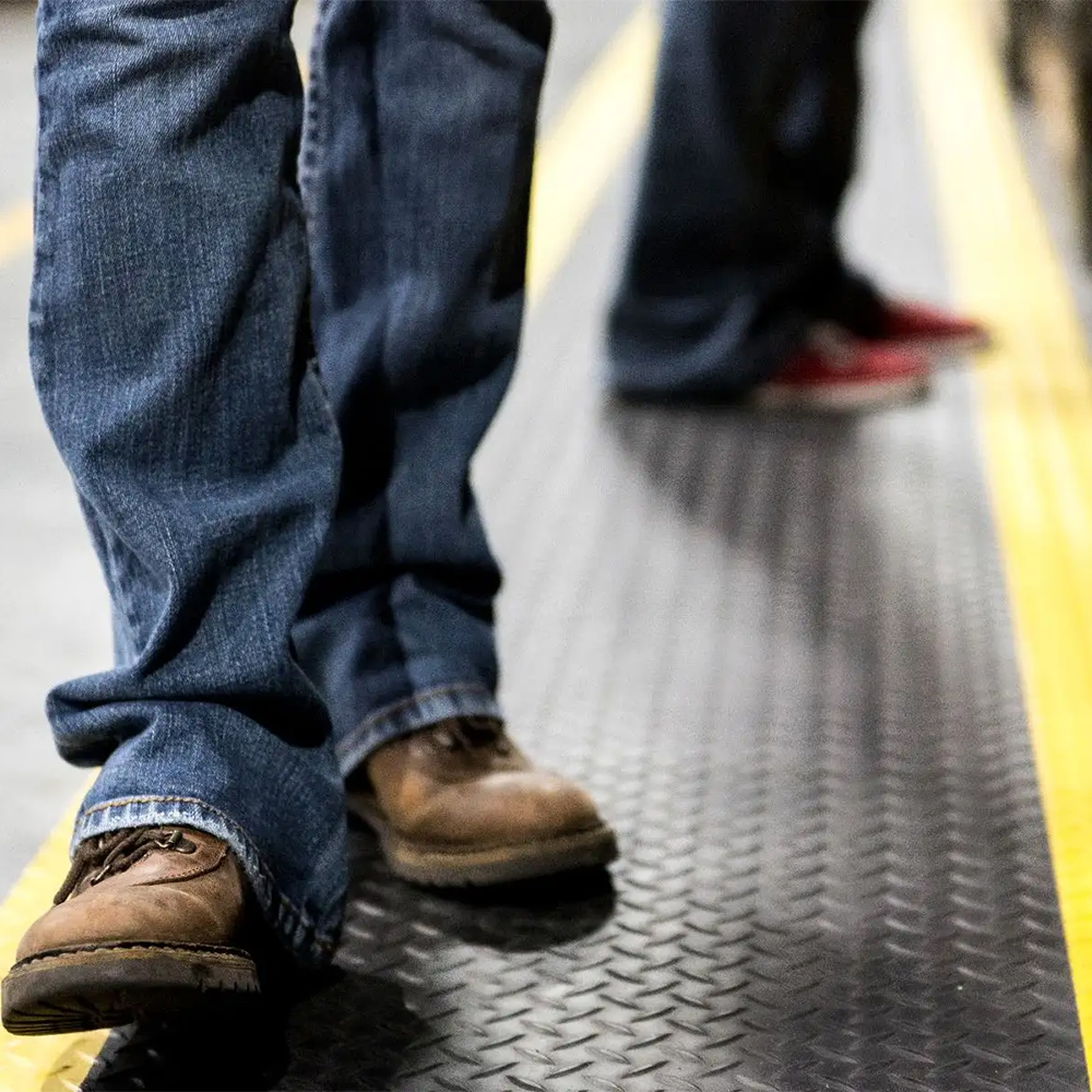 Wearwell Diamond-Plate SpongeCote 2x75 Ft. Black w/Yellow Borders ruunner with workers walking
