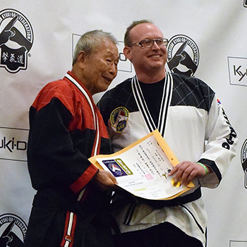 Brett Hart receiving black belt certificate for American Kyuki-Do Federation Founder Ok Hyung Kim
