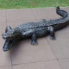 tan interlocking playground tiles installed on playground with alligator statue