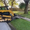 Skid steer on curb using landscape mat to protect grass Gmats 