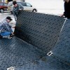 people installing links on ground protection mats to connect the mats together