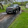 truck driving on ground protection mats in muddy driveway path