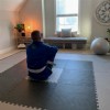 man sitting on bjj jiu jitsu grappling puzzle mats in exercise room