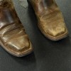 close up of smooth top horse stall mats with cowboy boots