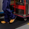 close up of person with cart walking on Firmagrip Industrial Matting in industrial facility